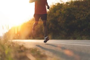 man running on the road at sunset